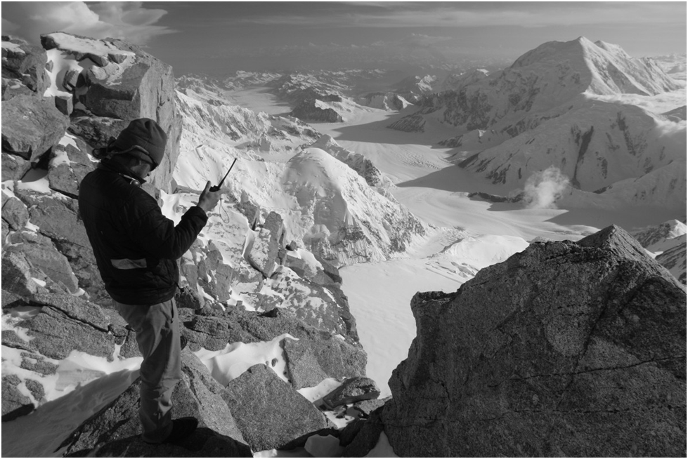 A hiker using a MURS walkie-talkie in the mountains